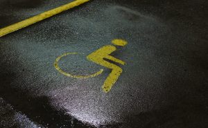 Žuti znak pristupačnosti za osobe s invaliditetom naslikan na asfaltu